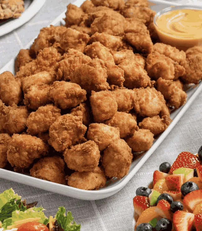A Chick-fil-A nugget tray with dipping sauce, fruit, and salad